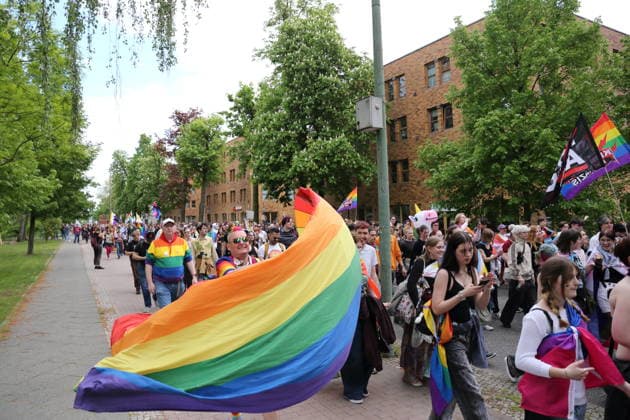 People walk with a rainbow flag in the Pappelallee during a demonstration for Christopher Street Day in Potsdam, May 9, 2026 CSD in Potsdam
