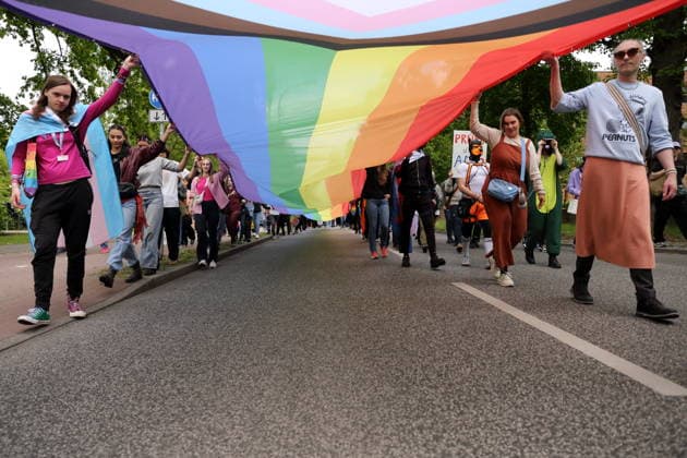 People walk with a rainbow flag in the Pappelallee during a demonstration for Christopher Street Day in Potsdam, May 9, 2026 CSD in Potsdam