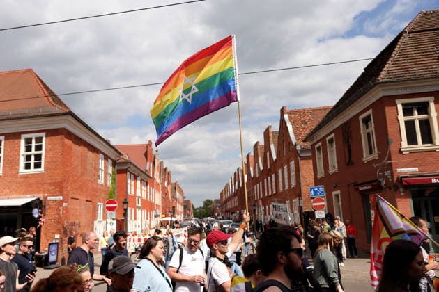 People walk with a rainbow flag at the Dutch Quarter in Friedrich Ebert Straße during a demonstration for Christopher Street Day in Potsdam, May 9, 2026 CSD in Potsdam