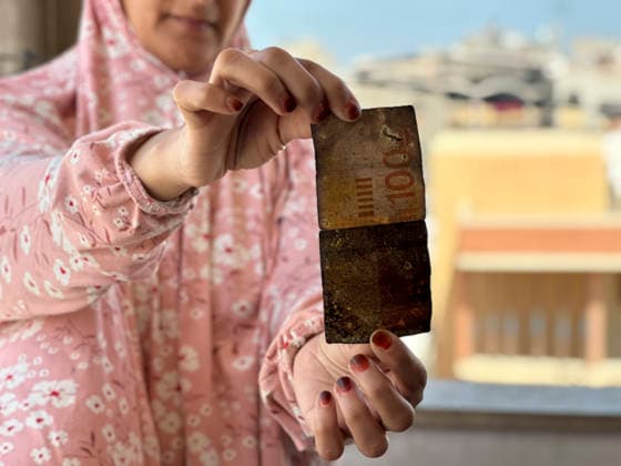 Israeli Strike in Khan Younis May 10 A woman holds a damaged banknote following an Israeli strike in the Al-Amal neighbourhood of Khan Younis in the southern Gaza Strip on May 10, 2026. According to Palestinian sources, the strike targeted a Hyundai Tucson vehicle near a junction in the area, killing two people and wounding several others. Khan Yunis Gaza Strip Palestinian Territories Copyright: xDoaaxAlbazx