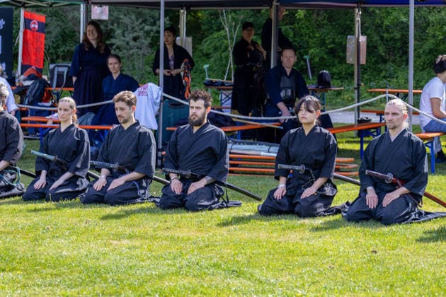 Augsburg, Bavaria, Germany May 10, 2026: Members of a Japanese martial arts group kneel on a lawn with traditional swords. The demonstration combines discipline, meditation, and elements of samurai culture with Asian swordsmanship. Traditional Japanese Spring Festival at the Augsburg Botanical Garden. The event is part of the garden™s 90th anniversary celebrations