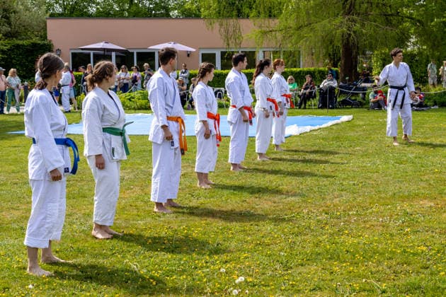 Augsburg, Bavaria, Germany May 10, 2026: A karate group wearing belts of different colors during a joint outdoor training session. The participants are practicing techniques and movements of the Japanese martial art under the guidance of an instructor. Traditional Japanese Spring Festival at the Augsburg Botanical Garden. The event is part of the garden™s 90th anniversary celebrations