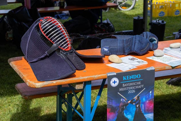 Augsburg, Bavaria, Germany May 10, 2026: Kendo equipment, including a helmet and gloves, on a table. A sign for the 2026 Bavarian Championship highlights competitions and training in this Japanese martial art. Traditional Japanese Spring Festival at the Augsburg Botanical Garden. The event is part of the garden™s 90th anniversary celebrations