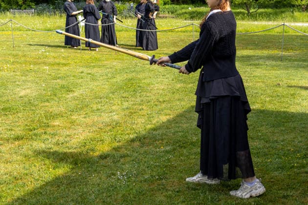 Augsburg, Bavaria, Germany May 10, 2026: A participant holding a training sword during a demonstration of Japanese martial arts on a lawn. The exercise combines concentration, discipline, and traditional techniques of Asian sword fighting. Traditional Japanese Spring Festival at the Augsburg Botanical Garden. The event is part of the garden™s 90th anniversary celebrations
