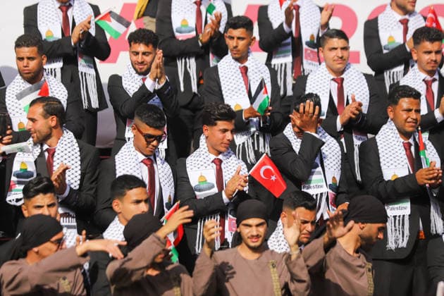 Mass Wedding Gaza City May 11 Grooms stand and clap on the steps of a stage during a mass wedding celebration in Gaza City, Gaza Strip, on May 11, 2026. The mass wedding celebration for 50 grooms, identified by organizers as orphans of conflict casualties, is sponsored by the Turkish Humanitarian Relief Foundation (IHH). Gaza Gaza Strip Palestinian Territories Copyright: xAhmedxAlxArinix