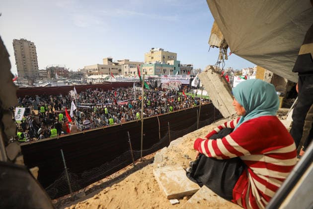 Mass Wedding Gaza City May 11 A woman sits in the balcony of a heavily damaged building overlooking a mass wedding celebration in Gaza City, Gaza Strip, on May 11, 2026. The mass wedding celebration for 50 grooms, identified by organizers as orphans of conflict casualties, is sponsored by the Turkish Humanitarian Relief Foundation (IHH). Gaza Gaza Strip Palestinian Territories Copyright: xAhmedxAlxArinix