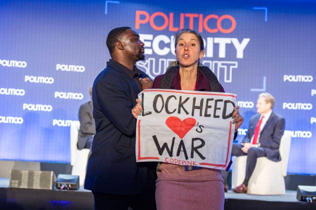May 12, 2026, Washington, District Of Columbia, USA: A protester holds a sign and shouts against the war at the POLITICO Security Summit on Tuesday, May 12, 2026, in Washington, D.C., a Lockheed Martin-sponsored event, during a discussion featuring Rep. Adam Smith and Rep. Michael R. Turner, who were speaking about the Iran war and President Donald TrumpÃ¢â‚¬â ¢s approach. The protester was removed from the room by security staff. Washington USA - ZUMAkh2_ 20260512_znp_kh2_033 Copyright: xAlixKhalighx