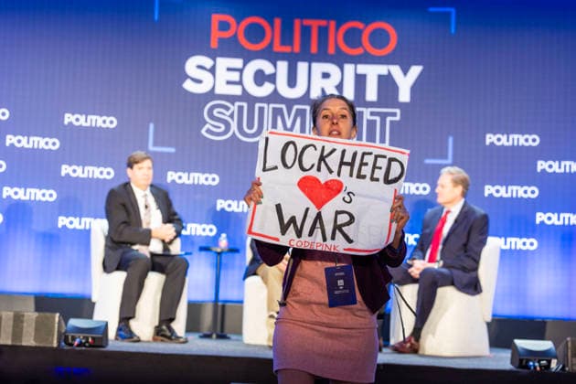 May 12, 2026, Washington, District Of Columbia, USA: A protester holds a sign and shouts against the war at the POLITICO Security Summit on Tuesday, May 12, 2026, in Washington, D.C., a Lockheed Martin-sponsored event, during a discussion featuring Rep. Adam Smith and Rep. Michael R. Turner, who were speaking about the Iran war and President Donald TrumpÃ¢â‚¬â ¢s approach. The protester was removed from the room by security staff. Washington USA - ZUMAkh2_ 20260512_znp_kh2_034 Copyright: xAlixKhalighx