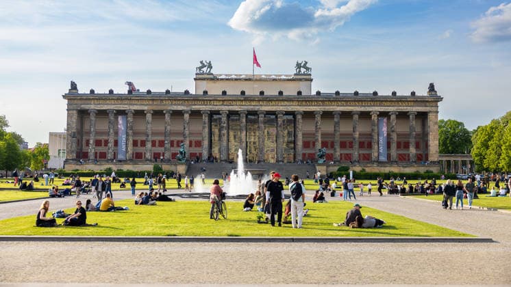 Altes Museum Berlin Lustgarten with fountain and spring hustle and bustle, Berlin, 10 05 2026 Front view of the Altes Museum at the Lustgarten in Berlin Mitte with the fountain in the foreground Numerous people relaxing on the lawn in the spring sunshine Banners for the exhibition Antike can be seen on the columned facade Berlin Mitte Berlin Germany 20260510-286A7024-M4000