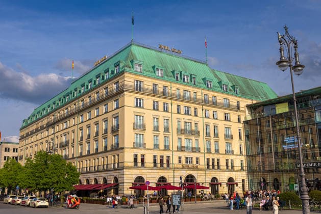 Hotel Adlon Kempinski Berlin Luxury hotel on Pariser Platz, Berlin, 10 05 2026 Exterior view of the Hotel Adlon Kempinski on Pariser Platz in Berlin Mitte near the Brandenburg Gate The historicizing façade with green copper roof and red outdoor gastronomy On the right the Academy of Arts Numerous visitors enliven the square Berlin Mitte Berlin Germany 20260510-286A7064-M4000