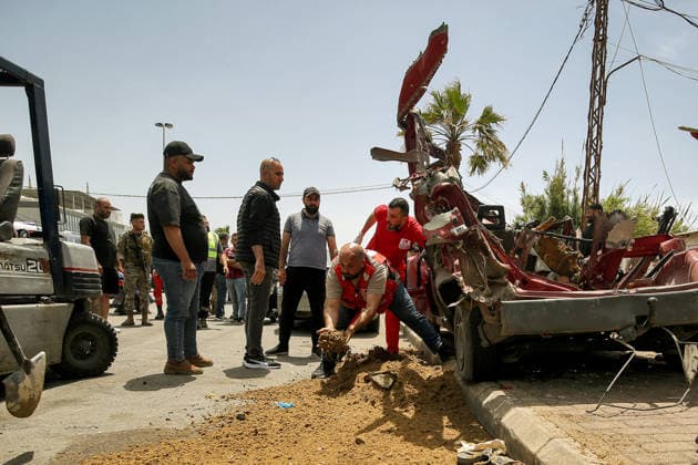 May 13, 2026, Sidon, Sidon, Lebanon: A civil defense member uses soil to cover blood near a vehicle that was targeted in an Israeli drone at the entrance of the southern port city of Sidon. Israel has kept up its airstrikes against the Iran-backed militant group Hezbollah despite a truce in place since April 17 aimed at halting the fighting. The violence comes with Lebanon and Israel due to hold a new round of direct negotiations in Washington on Thursday, brokered by the United States. Sidon Lebanon  - ZUMAn313 20260513_zip_n313_001 Copyright: xMarwanxNaamanix