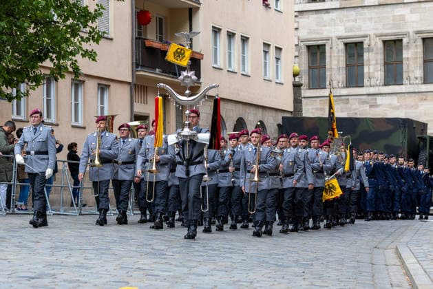 Public pledge of the Bundeswehr on Sebalder Platz, Nuremberg, 13 05 2026 The Veitshöchheim Army Music Corps marches onto Sebalder Platz with drum major, brass players and flag bearer in gray service uniform and red beret, followed by the honorary formation of the Bundeswehr Nuremberg Old Town Saint Sebald Bavaria Germany 20260513-1V9A8115-M4000
