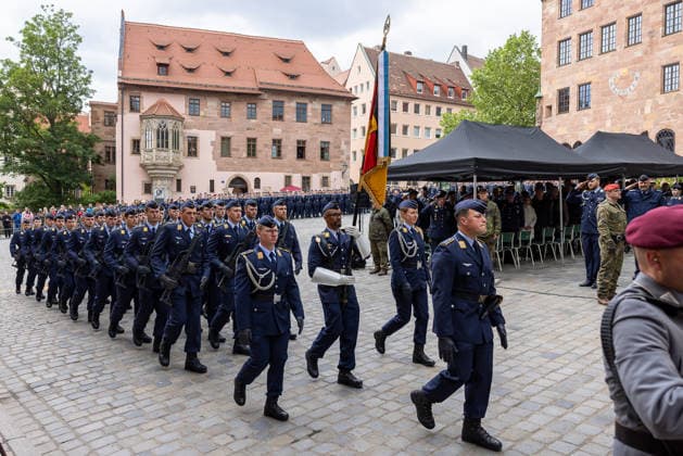 Public pledge of the Bundeswehr on Sebalder Platz, Nuremberg, 13 05 2026 The Air Force honor formation marches out with troop flag and shouldered rifle after the ceremonial pledge Officers and guests salute during the march past Nuremberg Old Town Saint Sebald Bavaria Germany 20260513-286A7442-M4000