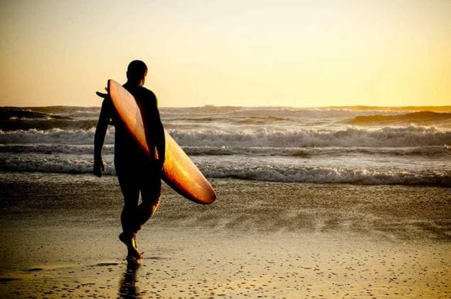 Surfer walking on the beach with the waves at sunset in Portugal. model released Symbolfoto Copyright: xhomydesignx Panthermedia68784256.jpg