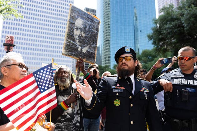 May 13, 2026, Houston, Texas, USA: During a No Kings protest at Houston City Hall in Houston, a demonstrator, Sgt. ABOYTE, who served in the U.S. Marine Corps and U.S. Army, speaks with the Houston police about the representation of his flag. Houston USA  - ZUMA 20260513_mda_g287_015 Copyright: xMatthewxGuzmanx