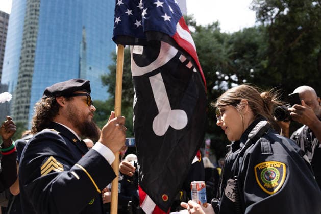 May 13, 2026, Houston, Texas, USA: During a No Kings protest at Houston City Hall in Houston, a demonstrator, Sgt. ABOYTE, who served in the U.S. Marine Corps and U.S. Army, speaks with the Houston police about the representation of his flag. Houston USA - ZUMA 20260513_mda_g287_017 Copyright: xMatthewxGuzmanx