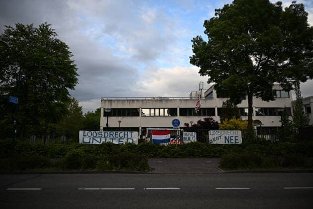 Violent Protest at Asylum Shelter in Loosdrecht LOOSDRECHT, NETHERLANDS - MAY 13: A view of the asylum shelter with banners and a Netherlands flag hung on the barriers as police officers and emergency services respond after a protest outside a temporary asylum shelter turned violent, leading to several arrests after demonstrators reportedly set fires and launched projectiles near the facility in Loosdrecht, Netherlands, on May 13, 2026. Mouneb Taim Anadolu Loosdrecht Netherlands. Editorial use only. Please get in touch for any other usage.  Copyright: x2026xAnadoluxMounebxTaimx