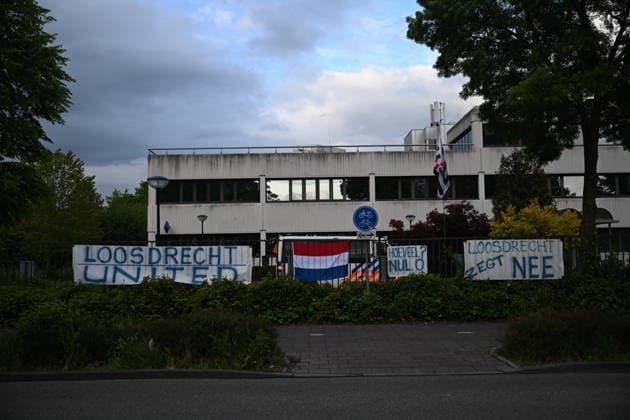 Violent Protest at Asylum Shelter in Loosdrecht LOOSDRECHT, NETHERLANDS - MAY 13: A view of the asylum shelter with banners and a Netherlands flag hung on the barriers as police officers and emergency services respond after a protest outside a temporary asylum shelter turned violent, leading to several arrests after demonstrators reportedly set fires and launched projectiles near the facility in Loosdrecht, Netherlands, on May 13, 2026. Mouneb Taim Anadolu Loosdrecht Netherlands. Editorial use only. Please get in touch for any other usage.  Copyright: x2026xAnadoluxMounebxTaimx