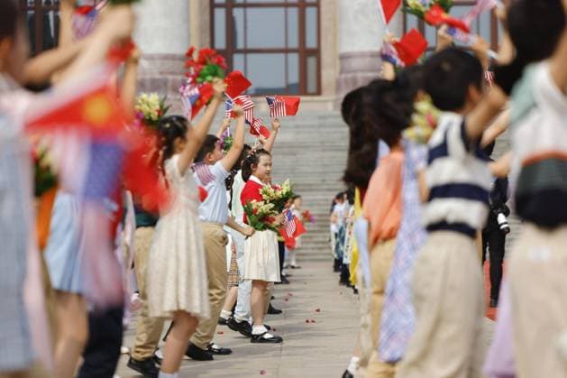 U.S.-China summit in Beijing Children wave U.S. and Chinese flags in front of the Great Hall of the People in Beijing ahead of a summit meeting between U.S. President Donald Trump and Chinese President Xi Jinping on May 14, 2026. (Pool photo)  A14AA0005555130P