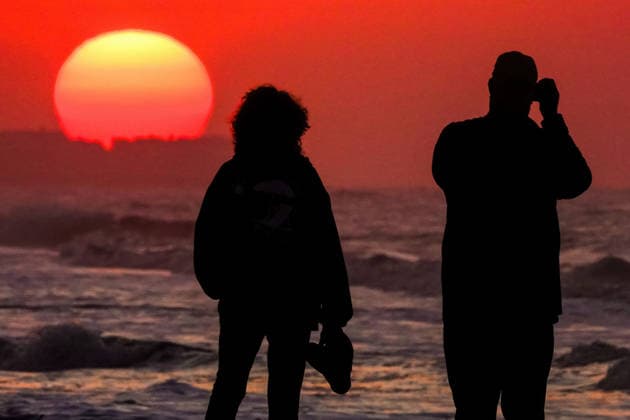 May 14, 2026, Isle Of Palms, Sc, United States: A couple silhouetted by the sunrise over the Atlantic Ocean takes photos on a hazy morning along Front Beach, May 14, 2026 in Isle of Palms, South Carolina. Isle Of Palms United States - ZUMAe02_ 20260514_zaf_e02_009 Copyright: xRichardxEllisx