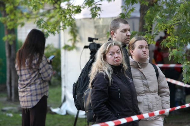 People watch a response effort to a Russian missile and drone strike in Kyiv, Ukraine, on May 14, 2026. Russia launched a massive attack on the Ukrainian capital, deploying more than 670 strike drones and 56 missiles of various types. The attack damaged 11 multi-storey residential buildings, cars, a supermarket, two car dealerships, two petrol stations, a business centre, and a service station. At least seven people were killed, and 39 people were injured, including an infant. (Photo by Oleksandr Klymenko Ukrinform) Kyiv comes under massive attack of Russian drones and missiles Copyright: xOleksandrxKlymenkox