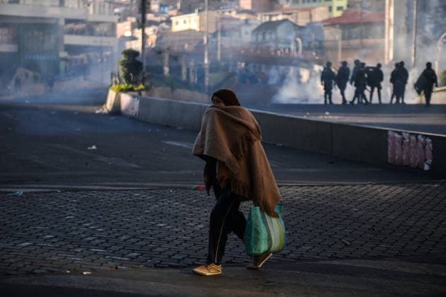 Miners attempt to break through police cordon in La Paz LA PAZ, BOLIVIA - MAY 14: A civilian woman flees from tear gas during clashes between police and protesting miners in downtown La Paz, Bolivia, on May 14, 2026. Carlos Sanchez Navas Anadolu La Paz Bolivia. Editorial use only. Please get in touch for any other usage.  Copyright: x2026xAnadoluxCarlosxSanchezxNavasx