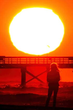 May 15, 2026, Isle Of Palms, Sc, United States: A beachgoer silhouetted by the sunrise stops to watch as the giant orange ball climbs over the Atlantic Ocean on a chilly morning along Front Beach, May 15, 2026 in Isle of Palms, South Carolina. Isle Of Palms United States - ZUMAe02_ 20260515_zaf_e02_005 Copyright: xRichardxEllisx