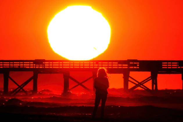 May 15, 2026, Isle Of Palms, Sc, United States: A beachgoer silhouetted by the sunrise stops to watch as the giant orange ball climbs over the Atlantic Ocean on a chilly morning along Front Beach, May 15, 2026 in Isle of Palms, South Carolina. Isle Of Palms United States - ZUMAe02_ 20260515_zaf_e02_006 Copyright: xRichardxEllisx