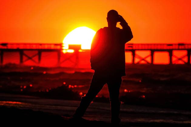 May 15, 2026, Isle Of Palms, Sc, United States: A beachgoer silhouetted by the sunrise stops to take a photo of the dramatic scene on a chilly morning along Front Beach, May 15, 2026 in Isle of Palms, South Carolina. Isle Of Palms United States - ZUMAe02_ 20260515_zaf_e02_007 Copyright: xRichardxEllisx