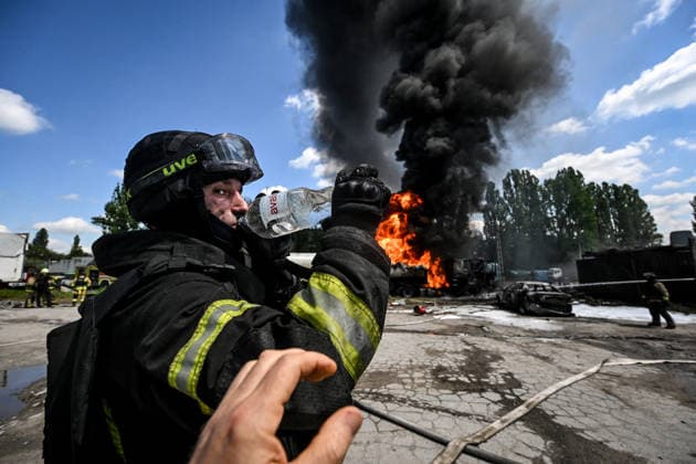 A firefighter drinks water as rescuers extinguish burning tank trucks used by a private company to supply petrol station chains after a Russian drone attack in Zaporizhzhia, Ukraine, on May 15, 2026. Russian troops struck an industrial facility, damaging a fuel cistern and causing tank trucks to catch fire. One civilian employee (a driver) was killed, and three other company employees sustained serious injuries in the explosion. (Photo by Dmytro Smolienko Ukrinform) Russian troops strike fuel truck fleet in Zaporizhzhia  Copyright: xDmytroxSmolienkox