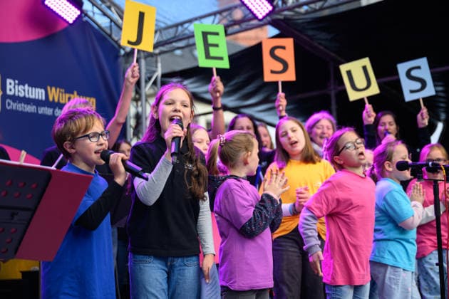 A childrens choir on the stage at the Upper Market at the Katholikentag in Wuerzburg Photo from 15 05 2026 Several tens of thousands of participants are expected to attend a total of 900 events until Sunday at the 104th German Katholikent Copyright: epd-bild DanielxPeter epd-Katholikentag_Wuerzburg135-kopieren