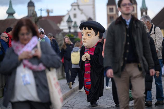 A person with a Luther costume on the Old Main Bridge during the Catholic Day in Wuerzburg Photo from 15 05 2026 Several tens of thousands of participants are expected to attend a total of 900 events at the 104th German Ca Copyright: epd-bild DanielxPeter epd-Katholikentag_Wuerzburg138-kopieren