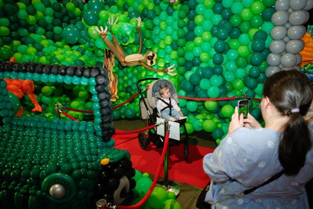 (260516) -- WARSAW, May 16, 2026 -- A woman takes photos of a child during the World Balloon Festival in Warsaw, Poland, May 15, 2026. The festival takes place here from May 15 to 17, featuring large themed installations featuring tropical jungles, underwater world, outer space and architectural landmarks created with more than 100,000 biodegradable balloons. (Photo by Xinhua) POLAND-WARSAW-WORLD BALLOON FESTIVAL JaapxArriens 