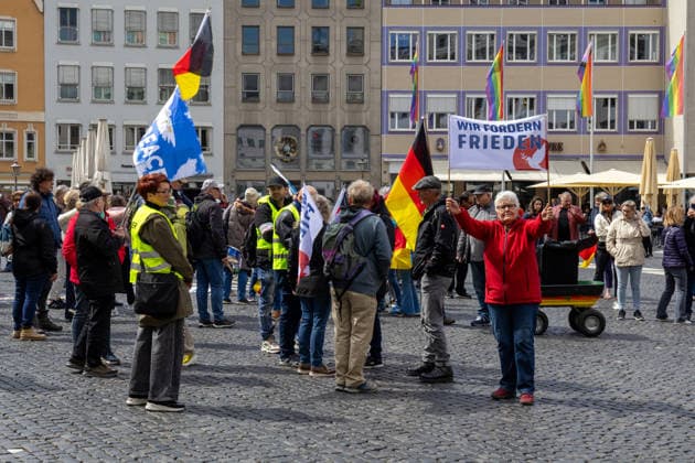 Augsburg, Bavaria, Germany May 16, 2026: Demonstration in Augsburg against the current federal government led by Chancellor Friedrich Merz. The slogan: Merz must go! Demonstrators carrying German flags