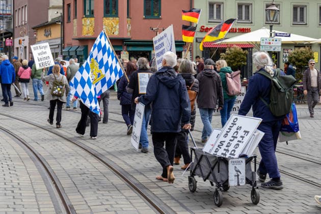 Augsburg, Bavaria, Germany May 16, 2026: Demonstration in Augsburg against the current federal government led by Chancellor Friedrich Merz. The slogan: Merz must go! Demonstrators carrying German flags