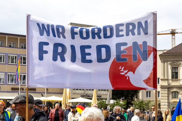 Augsburg, Bavaria, Germany May 16, 2026: Demonstration in Augsburg against the current federal government led by Chancellor Friedrich Merz. Under the slogan: Merz must go! Banner or poster: WE DEMAND PEACE