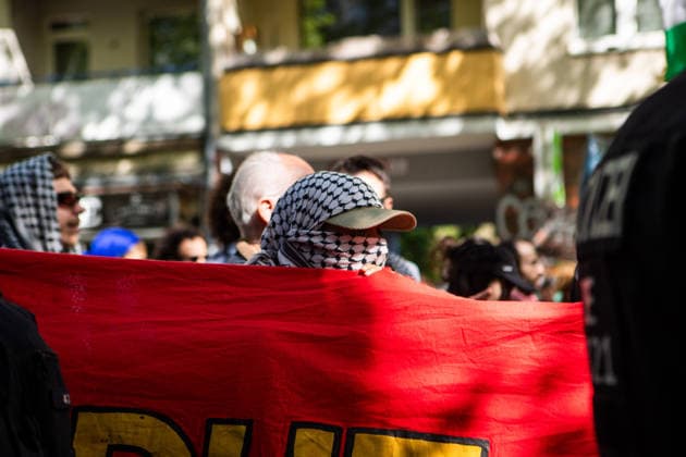 May 16, 2026, Berlin, Berlin, Germany: A protester protects his identity by covering his face with a Palestinian keffiyeh behind a red banner during the Nakba 78 demonstration in Berlin. Berlin Germany - ZUMAc291 20260516_zip_c291_005 Copyright: xMariaxCastrox