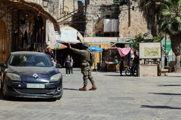 Hebron Israeli Settlers Tour May 16 An Israeli soldier signals a car to stop in the Old City of Hebron, the occupied West Bank, on May 16, 2026. The area is routinely secured by troops to allow Israeli settlers to tour the city. Hebron West Bank Palestinian Territories Copyright: xMosabxShawerx