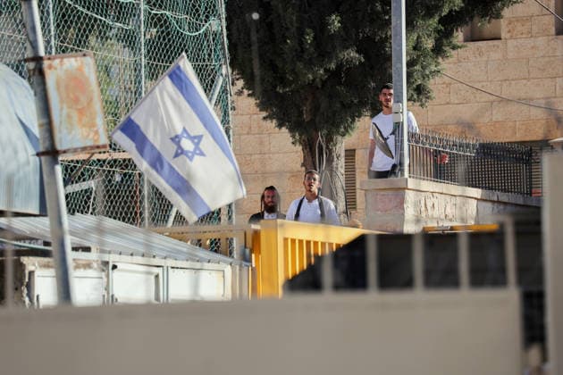 Hebron Israeli Settlers Tour May 16 Israeli settlers stand near a gate behind an Israeli flag in the Old City of Hebron, the occupied West Bank, on May 16, 2026. The area is routinely secured by troops to allow Israeli settlers to tour the city. Hebron West Bank Palestinian Territories Copyright: xMosabxShawerx