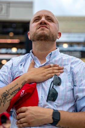 A man holding a MAGA hat worships during Rededicate 250 on the National Mall in Washington, DC on Sunday, May 17, 2026. The event, organized by Freedom 250 and the White House Faith Office, will feature political and faith leaders honoring 250 years of American history and encourage prayer or the country s next 250 years.  WAP20260517331 BONNIExCASH