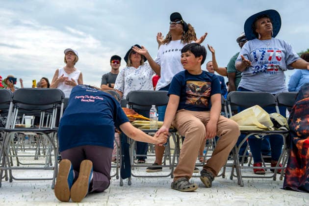 People hold hands while praying during Rededicate 250 on the National Mall in Washington, DC on Sunday, May 17, 2026. The event, organized by Freedom 250 and the White House Faith Office, will feature political and faith leaders honoring 250 years of American history and encourage prayer or the country s next 250 years.  WAP20260517332 BONNIExCASH