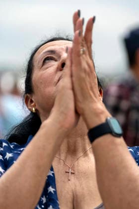 A woman worships during Rededicate 250 on the National Mall in Washington, DC on Sunday, May 17, 2026. The event, organized by Freedom 250 and the White House Faith Office, will feature political and faith leaders honoring 250 years of American history and encourage prayer or the country s next 250 years.  WAP20260517339 BONNIExCASH