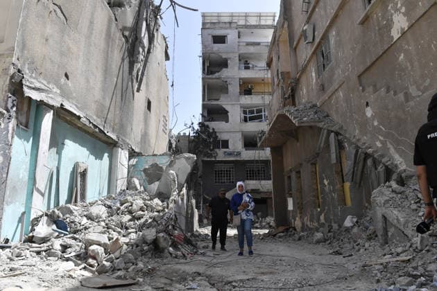 Israeli forces targets Tyre violating the ceasefire TYRE, LEBANON - MAY 17: People walk between damaged buildings as the Israeli army carried out an attack violating the ceasefire on the city of Tyre in southern Lebanon, on May 17, 2026. Houssam Shbaro Anadolu Tyre Lebanon. Editorial use only. Please get in touch for any other usage.  Copyright: x2026xAnadoluxHoussamxShbarox