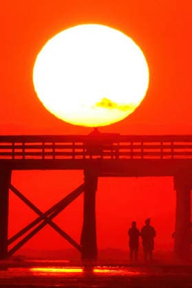 May 18, 2026, Isle Of Palms, Sc, United States: A couple silhouetted by the sunrise as they walk under the fishing pier on Front Beach, May 18, 2026 in Isle of Palms, South Carolina. Isle Of Palms United States - ZUMAe02_ 20260518_zaf_e02_011 Copyright: xRichardxEllisx