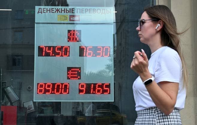 Russia Economy 9168268 18.05.2026 A young woman walks past a board showing currency exchange rates for the U.S. dollar and the euro against the Russian rouble in Moscow, Russia. Ilya Pitalev Sputnik Moscow Russia  Copyright: xIlyaxPitalevx