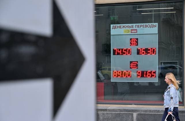 Russia Economy 9168298 18.05.2026 A woman walks past a board showing currency exchange rates for the U.S. dollar and the euro against the Russian rouble in Moscow, Russia. Ilya Pitalev Sputnik Moscow Russia  Copyright: xIlyaxPitalevx