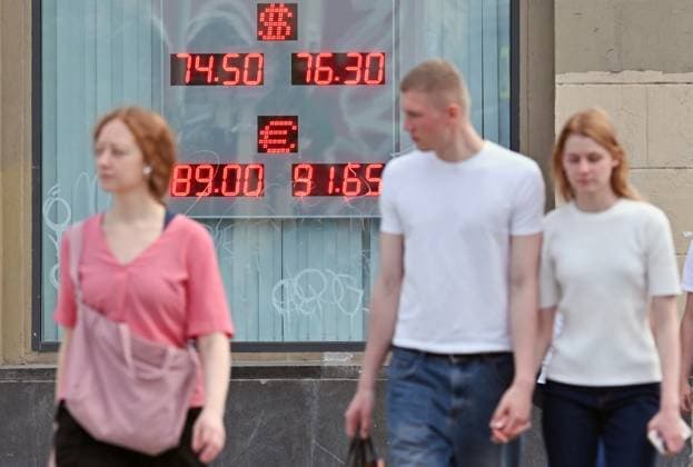 Russia Economy 9168284 18.05.2026 People walk past a board showing currency exchange rates for the U.S. dollar and the euro against the Russian rouble in Moscow, Russia. The dollar exchange rate, which serves as a benchmark for the over-the-counter market, fell below 72 rubles for the first time since February 8, 2023, according to trading data. Ilya Pitalev Sputnik Moscow Russia  Copyright: xIlyaxPitalevx