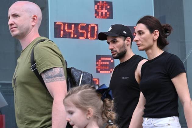 Russia Economy 9168311 18.05.2026 People walk past a board showing currency exchange rates for the U.S. dollar and the euro against the Russian rouble in Moscow, Russia. The dollar cross rate, which serves as a benchmark for the over-the-counter market, fell below 72 rubles for the first time since February 8, 2023, according to trading data. Ilya Pitalev Sputnik Moscow Russia  Copyright: xIlyaxPitalevx