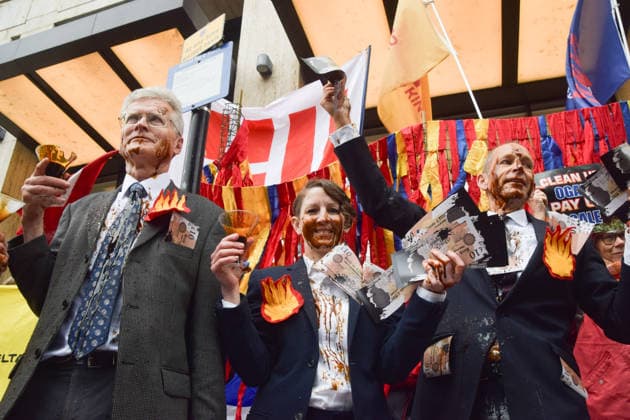 May 19, 2026, London, England, United Kingdom: Climate activists dressed as executives covered in Ã¢â‚¬ËœoilÃ¢â‚¬â ¢ (actually treacle) hold banknotes emblazoned with Bank on Climate Chaos as they stage a protest outside Shell headquarters on the day of the oil giantÃ¢â‚¬â ¢s Annual General Meeting, AGM. London United Kingdom - ZUMAv130 20260519_zip_v130_007 Copyright: xVukxValcicx
