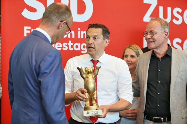 Berlin, Germany, 19 05 2026 German Bundestag SPD parliamentary group meeting SPD MP Johannes Fechner shows Federal Chancellor Friedrich Merz CDU the trophy dusted off by FC Bundestag at the 53 European Parliamentary Championships in Lübeck, right Federal Minister for Housing, Urban Development and Construction Verena Hubertz SPD and SPD parliamentary Copyright: xdtsxNachrichtenagenturx dts_119537